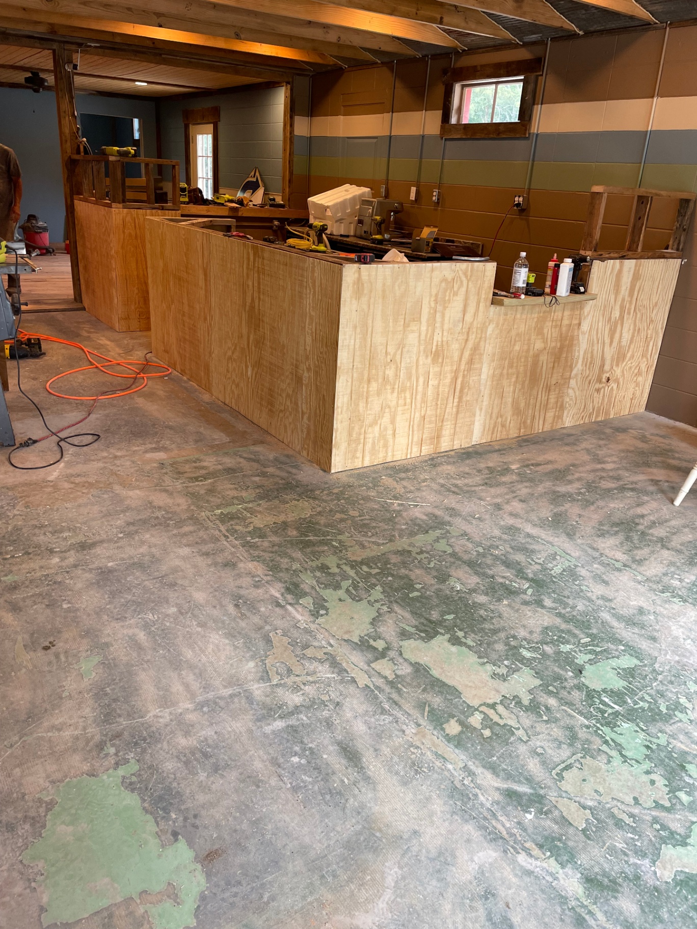 Custom bar framed and clad in raw plywood inside the shop