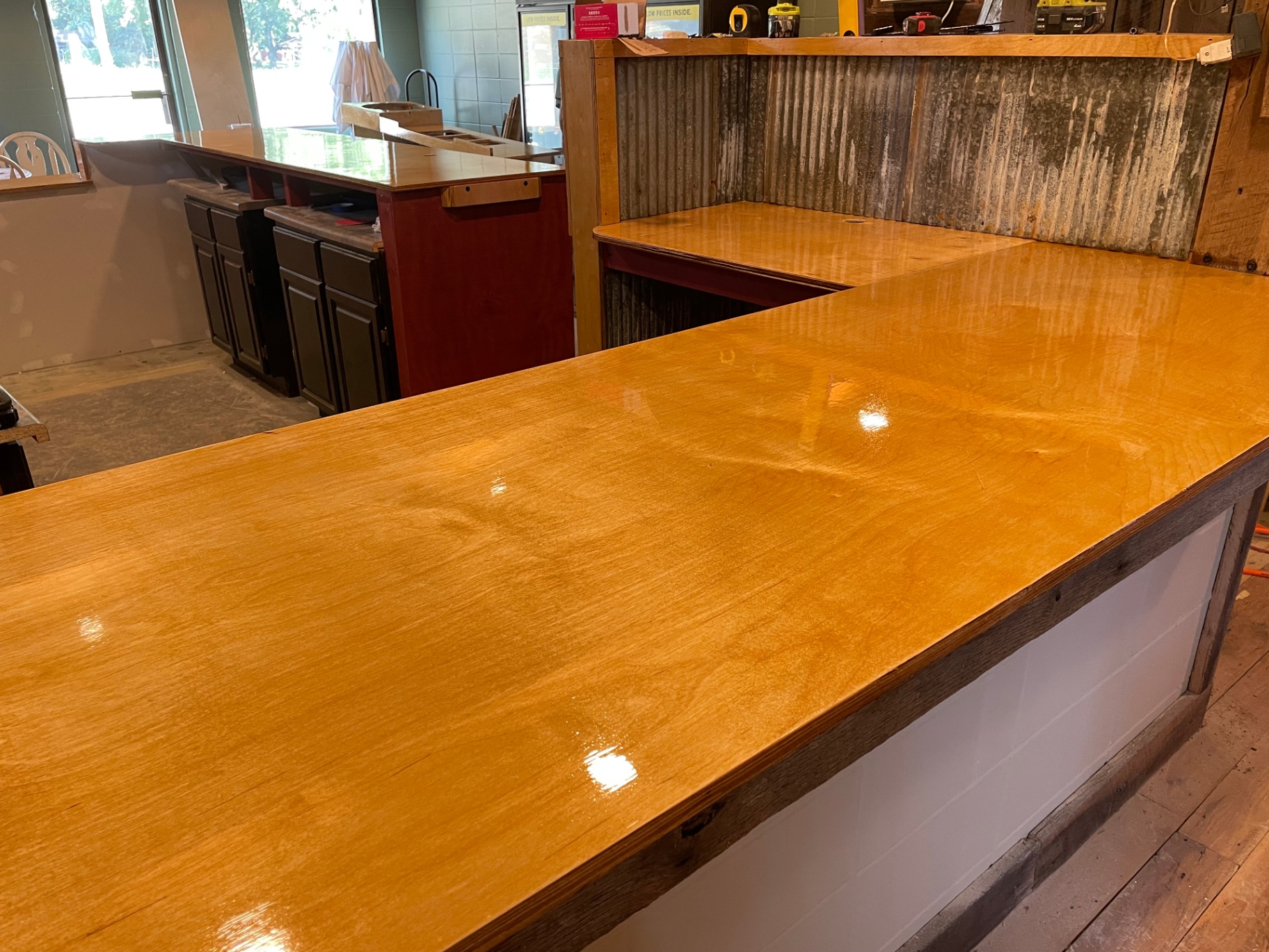 Glossy finished wood bar top with corrugated metal backsplash