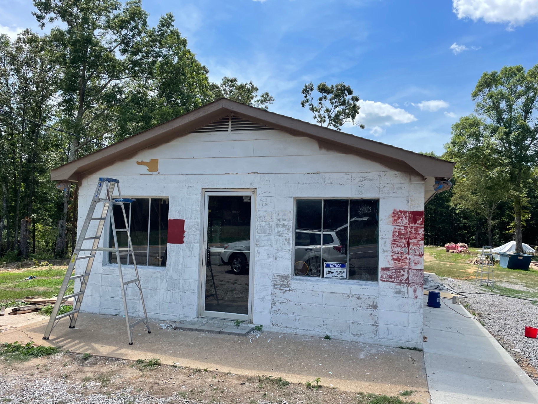 Coffee shop exterior before renovation — peeling white paint, ladder out front