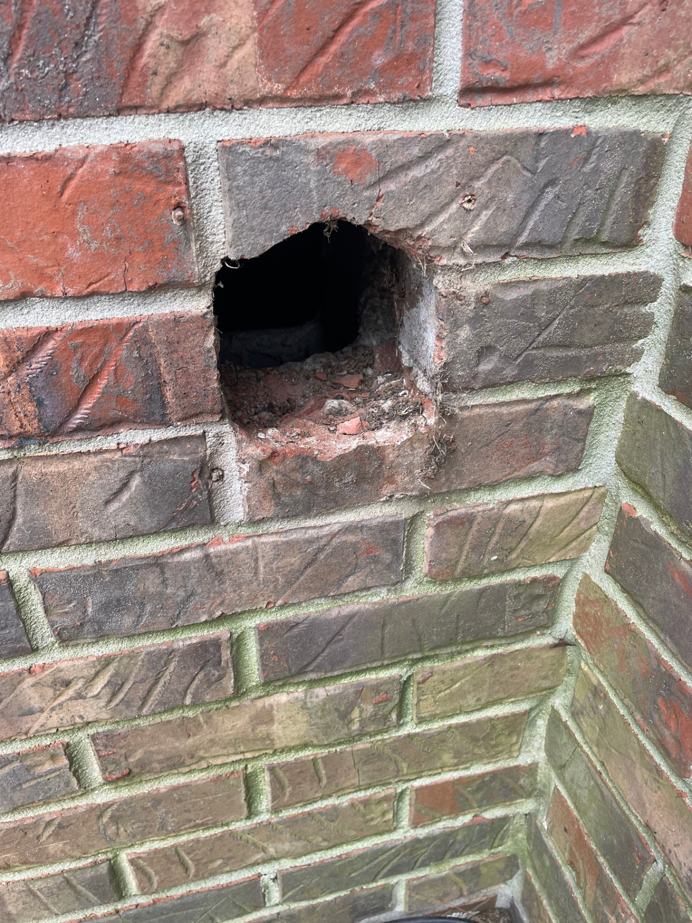 Exterior brick opening cleared and prepped after removing the old vent